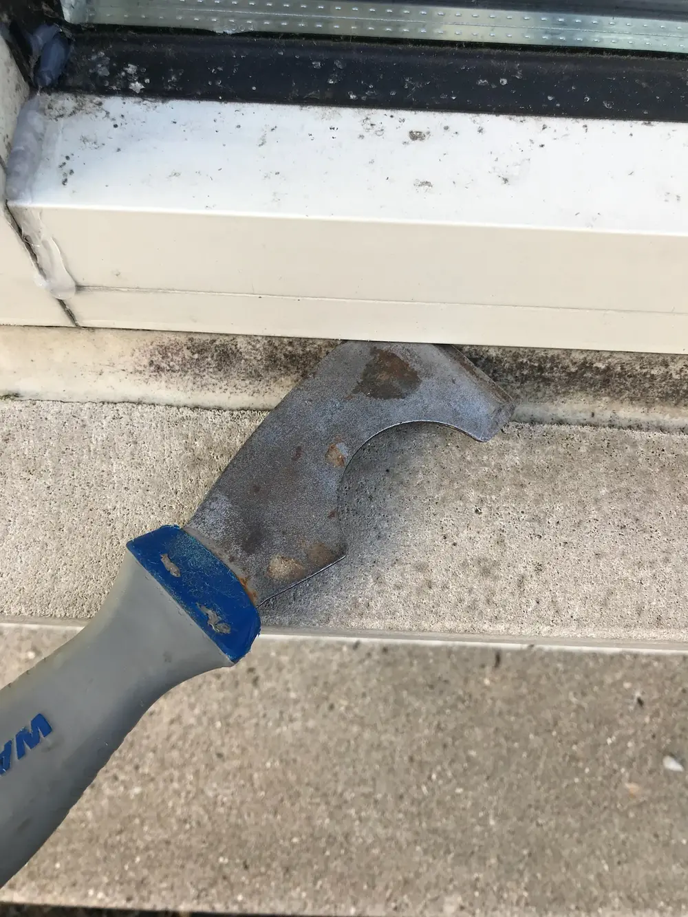 Scraper resting on a window sill during glass work