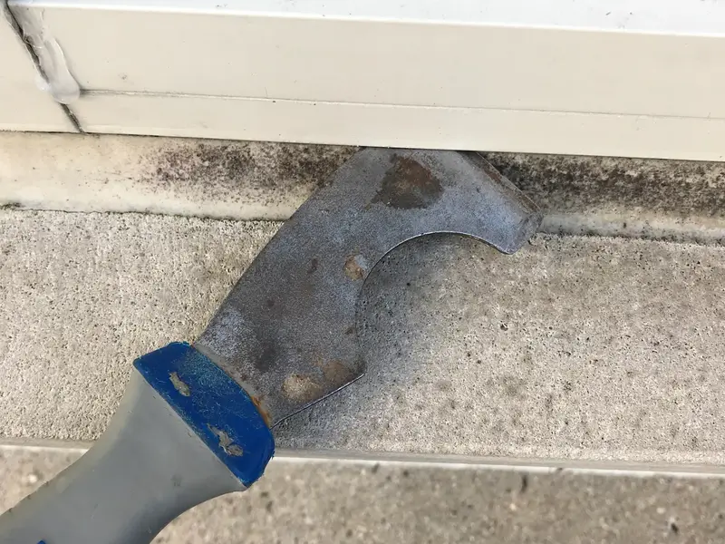 Scraper resting on a window sill during glass work