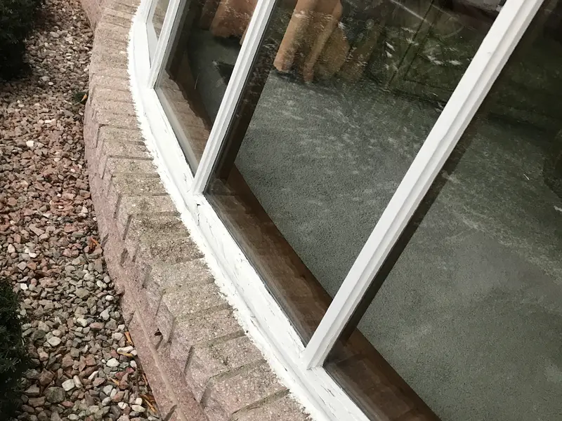 Curved bay window frames along a brick wall