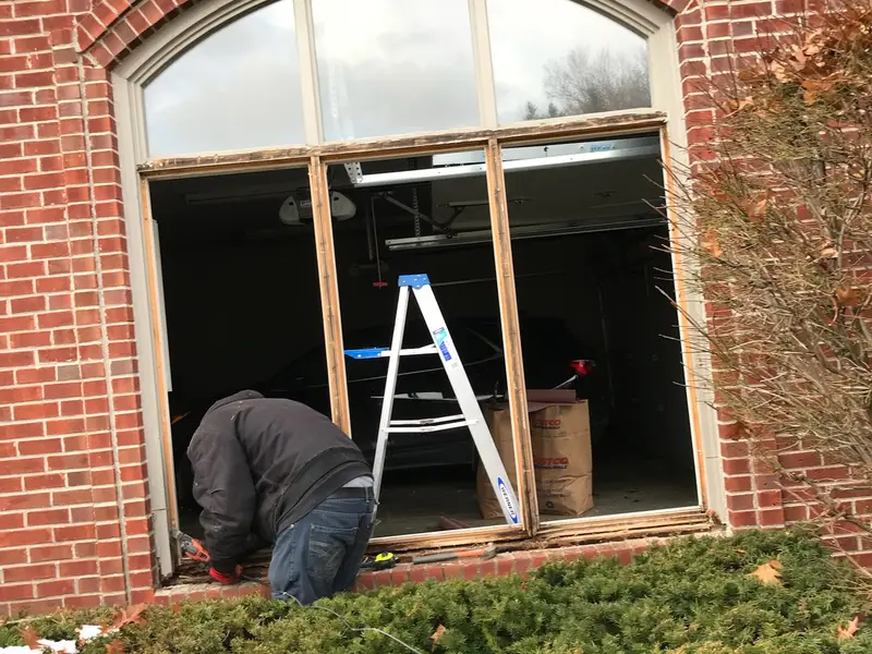 Arched window opening in a brick home with a technician working inside