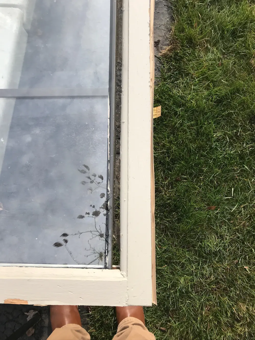 Window sash laid flat on the grass during repair